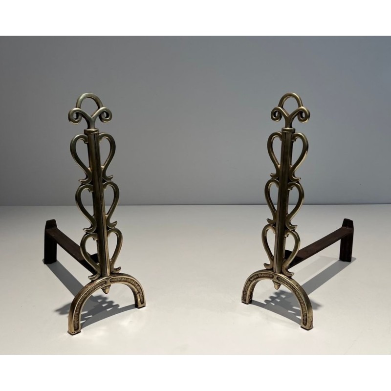 Pair of Brass and Wrought Iron Andirons with Stacked Heart-Lobe Uprights in the Manner of Raymond Subes. France. Circa 1940.