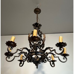 Important lustre en fer forgé à huit bras de lumières, au dessin sculptural et à la présence décorative affirmée.