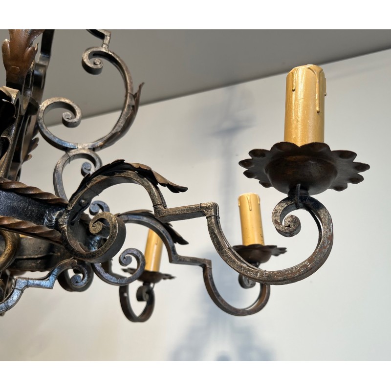 Important lustre en fer forgé à huit bras de lumières, au dessin sculptural et à la présence décorative affirmée.