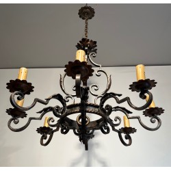 Important lustre en fer forgé à huit bras de lumières, au dessin sculptural et à la présence décorative affirmée.