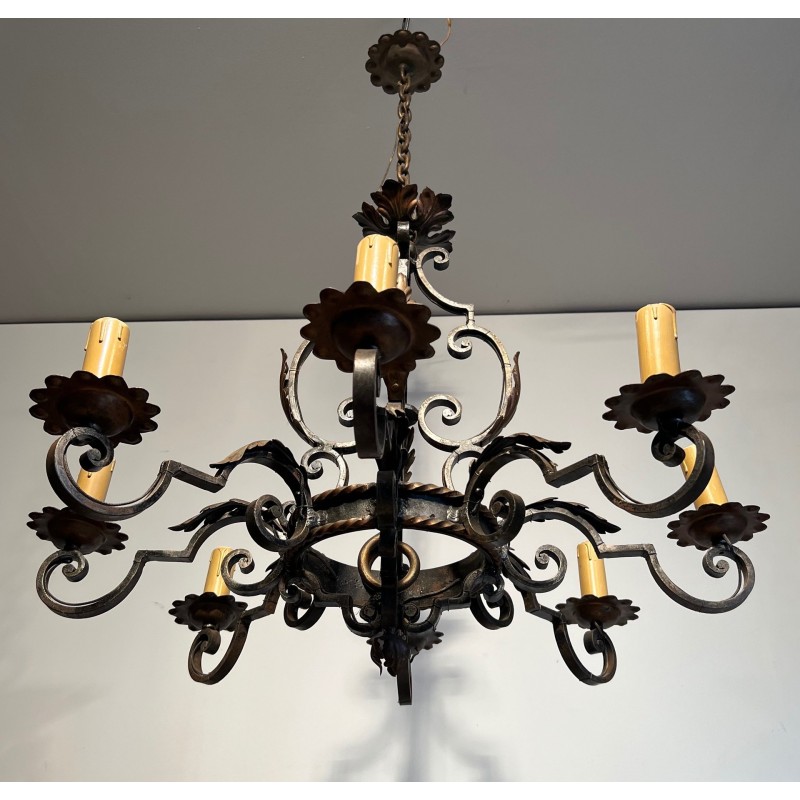 Important lustre en fer forgé à huit bras de lumières, au dessin sculptural et à la présence décorative affirmée.