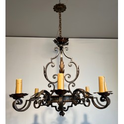 Important lustre en fer forgé à huit bras de lumières, au dessin sculptural et à la présence décorative affirmée.