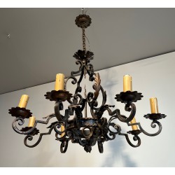Important lustre en fer forgé à huit bras de lumières, au dessin sculptural et à la présence décorative affirmée.